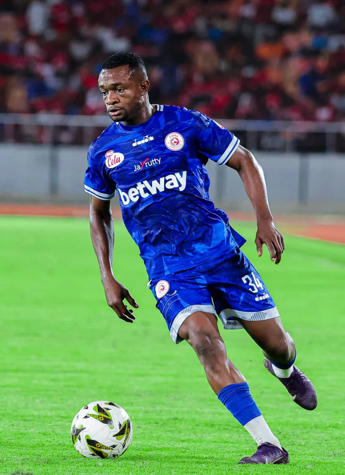 Soccer player in blue uniform with Betway logo on a field