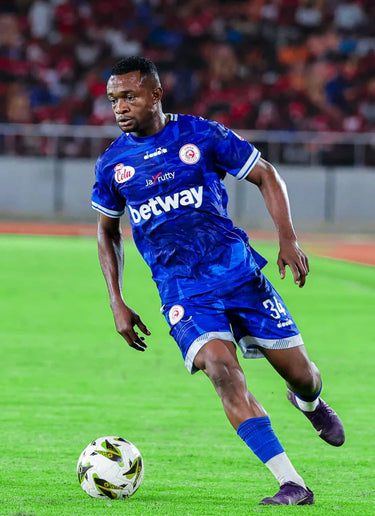 Soccer player in blue uniform with Betway logo on a field